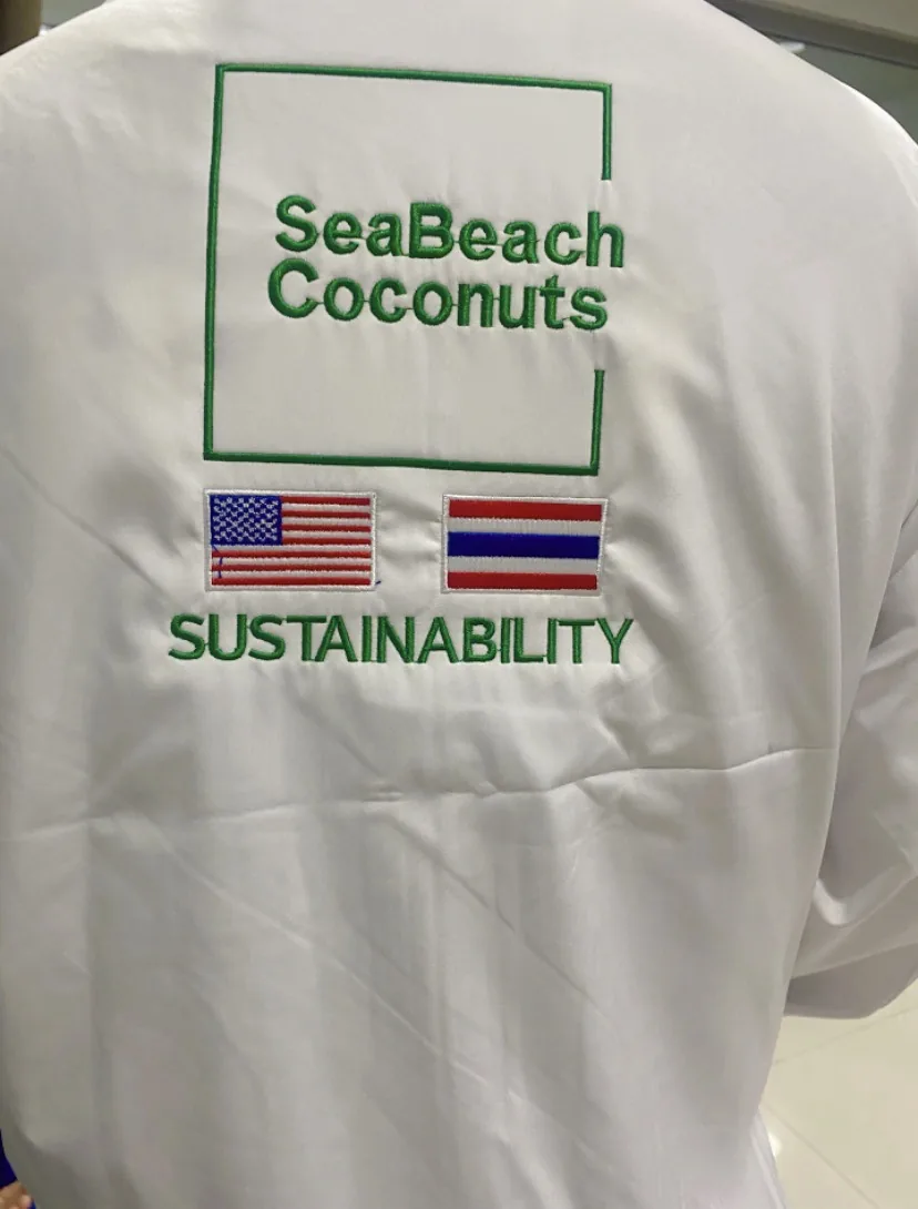 ด้านหลังชุดพนักงานปักโลโก้ SeaBeach Coconuts และคำว่า Sustainability